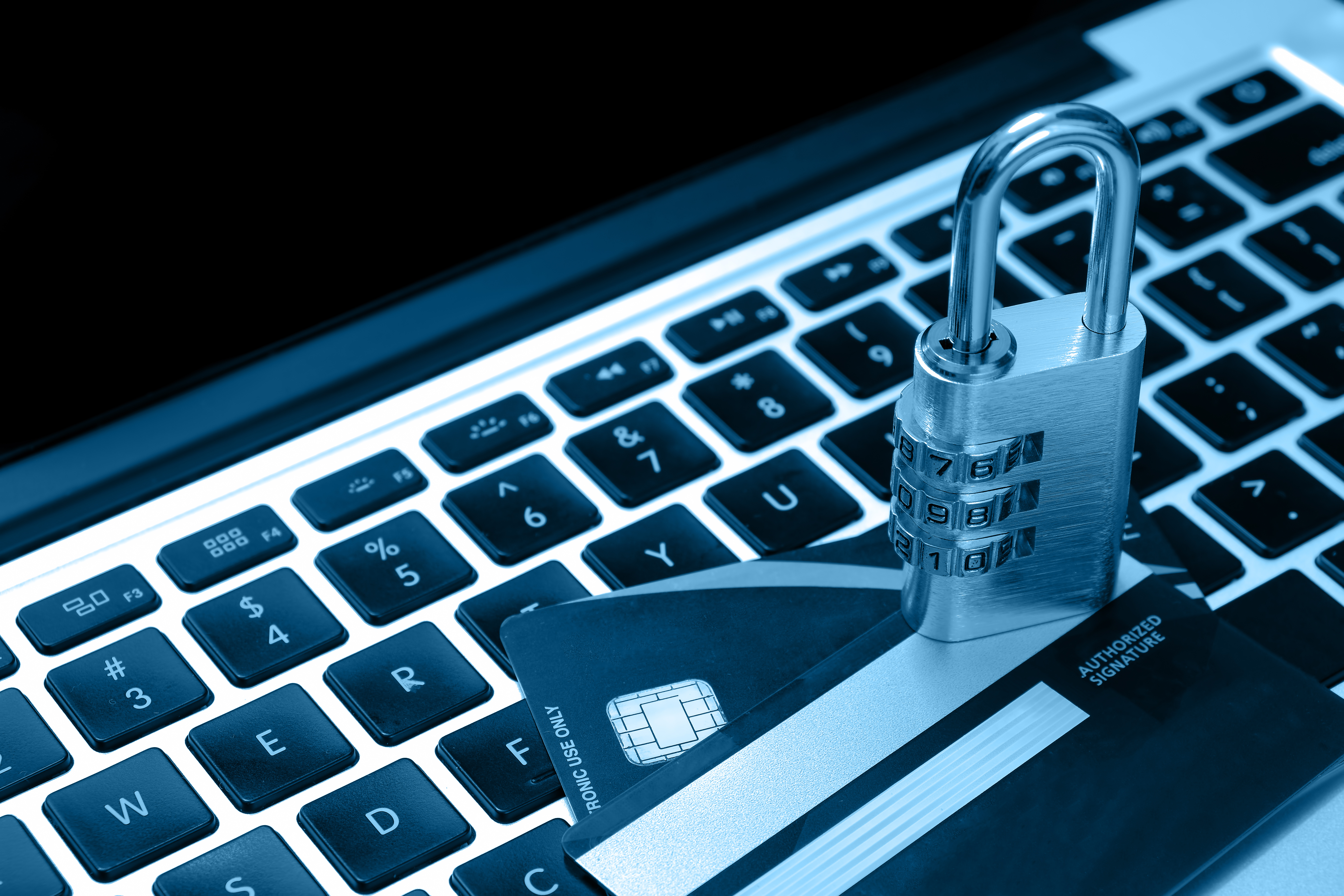 Credit card and padlock lying on keyboard symbolizing secure online shopping